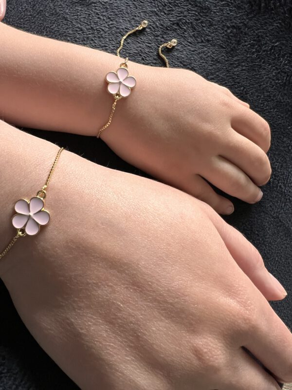 Armbandje goudkleurig met roze bloem bedel